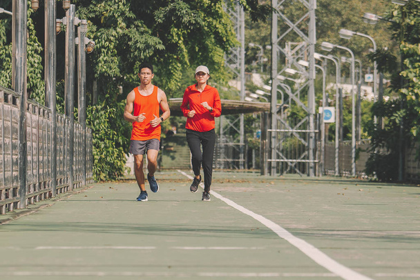 młody para biegacz biegnie po biegnącej drodze w parku miejskim; sport,  - Zdjęcie, obraz