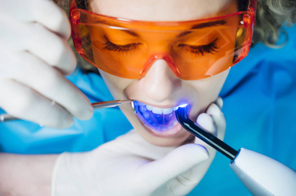 Стоматолог осматривает пациента с ультрафиолетовым излучением
 - Фото, изображение