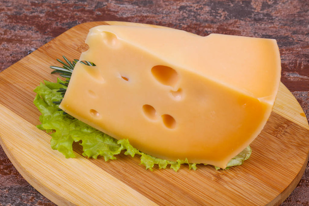 Maasdam-Käse im Brett serviert Salatblätter - Foto, Bild