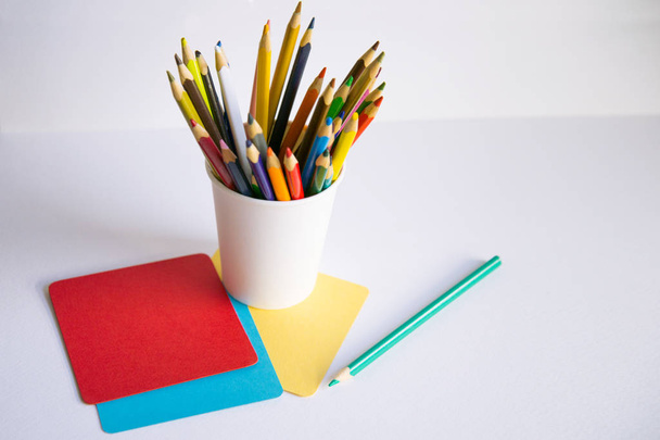 barevné tužky a papír na psaní na bílém pozadí - Fotografie, Obrázek