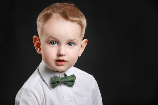 Portrait of stylish little boy on dark background - Foto, afbeelding