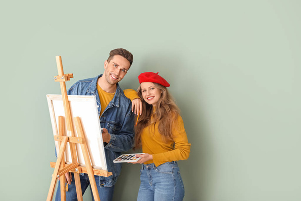 Couple of young artists on color background - Φωτογραφία, εικόνα