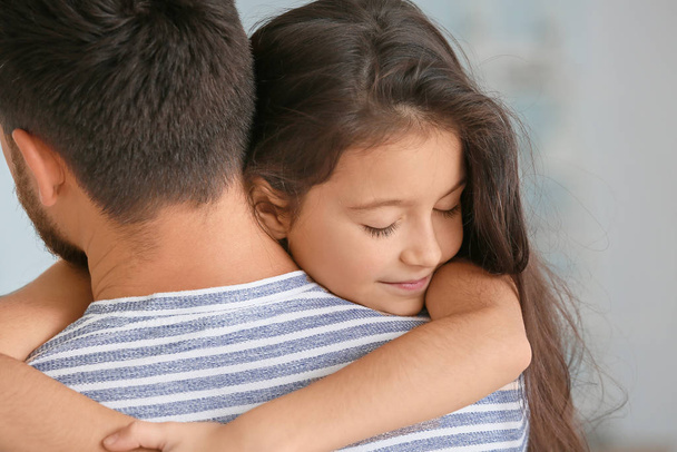 Αγκαλιάζοντας το κοριτσάκι με τον πατέρα στο σπίτι - Φωτογραφία, εικόνα