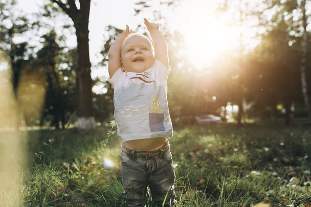 una pequeña mancha de niño caminando con las manos en alto y sonrisa increíble
 - Foto, Imagen