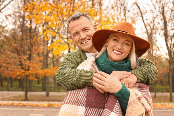 Happy mature couple in autumn park - Foto, afbeelding