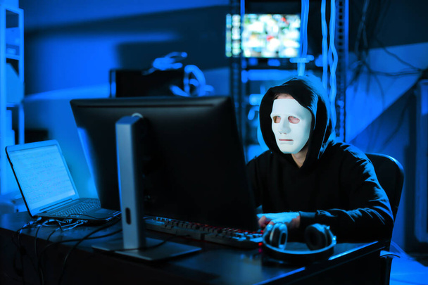Pirate professionnel utilisant l'ordinateur dans la chambre noire
 - Photo, image