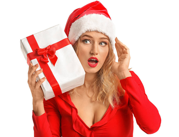 Mujer joven sorprendida en Santa sombrero y con regalo de Navidad sobre fondo blanco
 - Foto, imagen