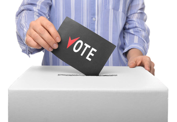 Mujer poniendo papeleta de votación en la caja de votación contra fondo blanco
 - Foto, Imagen