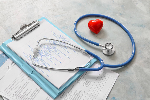 Stethoscope, heart and documents on light background. Cardiology concept - Photo, Image