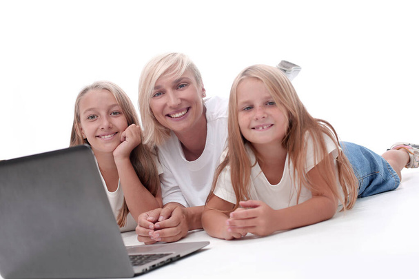 close up. mom and daughters lying in front of an open laptop. - Фото, зображення