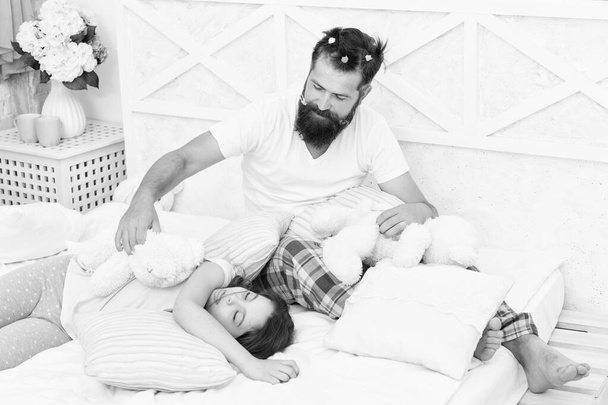Home day. happy morning together. good night. funny pajama party. small girl with bearded father in bed. weekend at home. father and daughter ready to sleep. family bonding time. i love my daddy - Photo, image