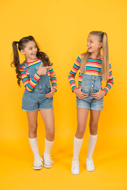 little girls yellow background. hairdresser salon. kid summer fashion. beauty and style. childhood happiness. happy school friendship. best friends forever. small children have fun - Photo, image