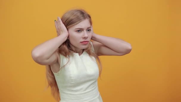 Mujer insatisfecha manteniendo los dedos en las orejas, mirando confundida con los ojos cerrados
 - Metraje, vídeo