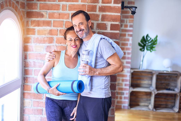 Schönes sportliches Paar mittleren Alters beim Yoga im Fitnessstudio - Foto, Bild