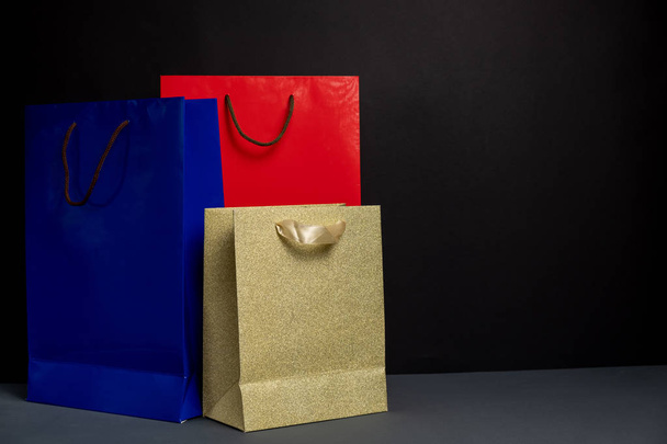 Three color paper Shopping bag isolated on black background. Packaging template mockup. Delivery concept advertising mock. Shopping Concept - Foto, afbeelding