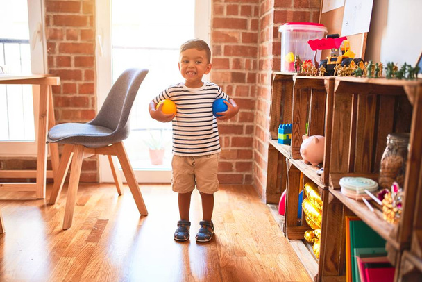 Bellissimo bambino ragazzo che gioca con le palline colorate all'asilo
 - Foto, immagini
