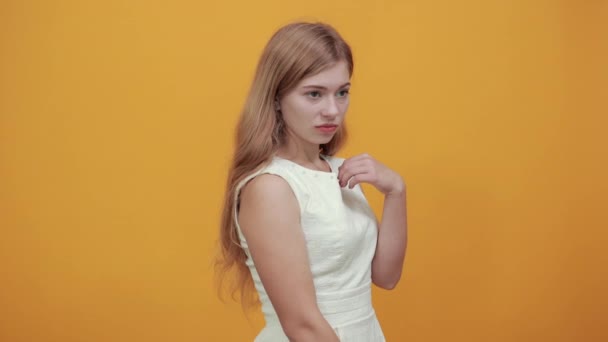 Poważna blondynka młoda kobieta stojąca bokiem, patrząca w kamerę - Materiał filmowy, wideo