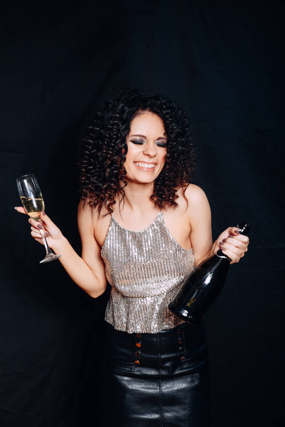 Beautiful woman celebrating New Year. Portrait of happy smiling girl in stylish dress with champagne at birthday party. - Valokuva, kuva
