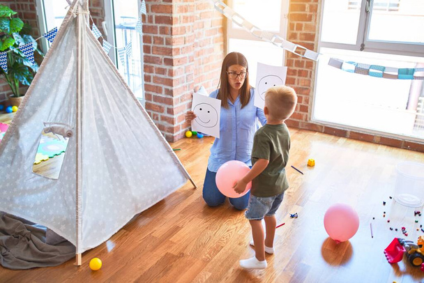 Mladá terapeutka mluví s dítětem, poradce a korekce chování v kanceláři kolem hraček - Fotografie, Obrázek
