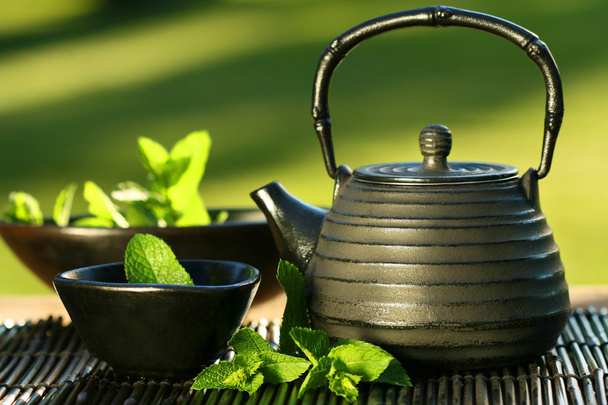 Tetera asiática negra con té de menta
 - Foto, imagen