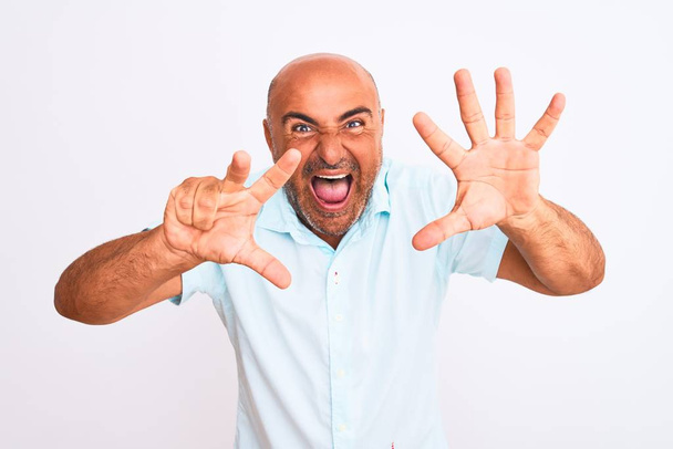 Středního věku pohledný muž nosí ležérní košili stojící nad izolované bílé pozadí ukazující a ukazující nahoru s prsty číslo osm při úsměvu sebevědomě a šťastně. - Fotografie, Obrázek