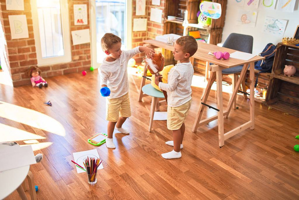 Sevimli sarışın ikizler, anaokulunda oyuncak oyuncaklarıyla oynuyorlar. - Fotoğraf, Görsel