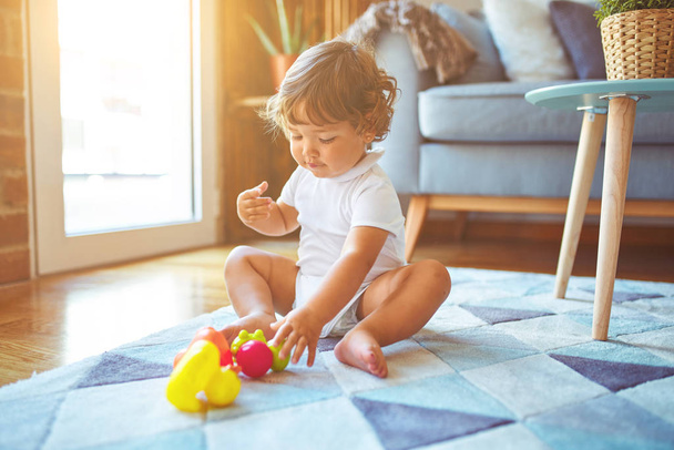 Menina criança bonita brincando com brinquedos no tapete
 - Foto, Imagem