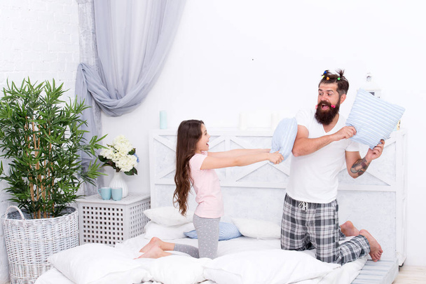 Time flies when you are having fun. Happy family have fun together. Little child and bearded man fight for fun. Pillow fight. Play games. Fun and entertainment. Family life - Foto, Imagen