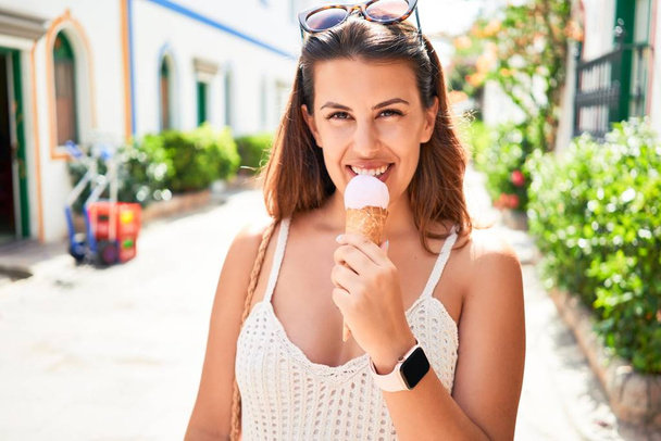 Joven hermosa mujer comiendo helado cono en un día soleado de verano en vacaciones
 - Foto, imagen