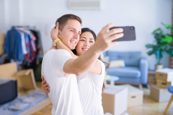 Young beautiful couple  at new home around cardboard boxes - Foto, imagen