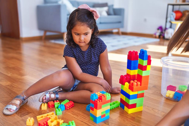 Beautiful toddler girl playing with construction blocks at kindergarten - Fotó, kép