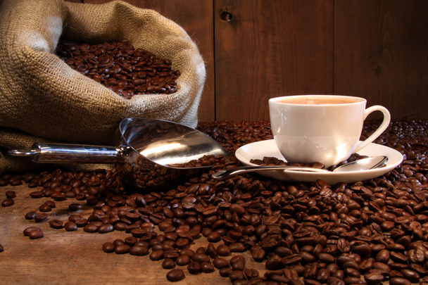 Taza de café con saco de arpillera de frijoles asados
 - Foto, Imagen