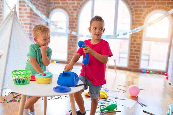 Adorable toddlers playing around lots of toys at kindergarten - Foto, Imagem