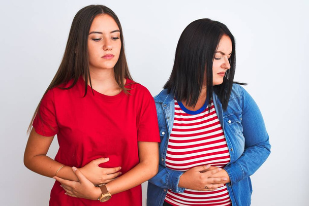 Young beautiful women wearing casual clothes standing over isolated white background with hand on stomach because indigestion, painful illness feeling unwell. Ache concept. - Photo, Image