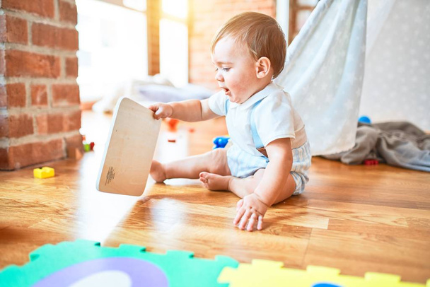 entzückendes Kleinkind spielt im Kindergarten um jede Menge Spielzeug - Foto, Bild