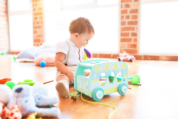 Adorable bambin jouant autour de beaucoup de jouets à la maternelle
 - Photo, image