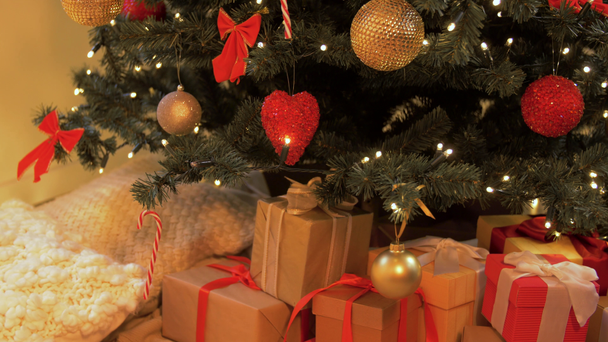 κουτιά δώρων κάτω από διακοσμημένο χριστουγεννιάτικο δέντρο στο σπίτι - Πλάνα, βίντεο