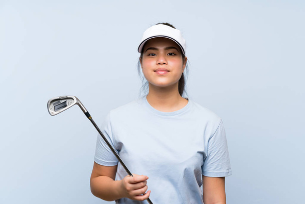 Young golfer Asian girl over isolated blue background - Foto, afbeelding