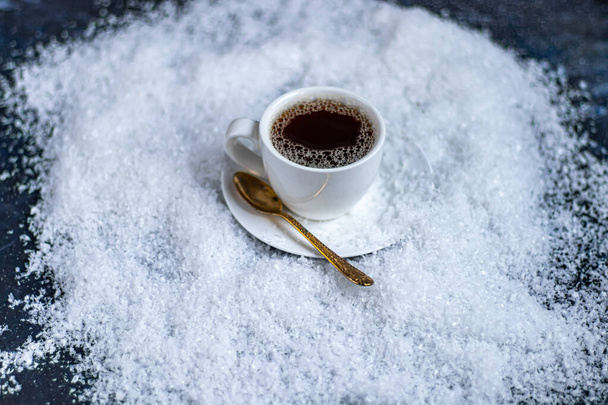 Sıcak kahveyle birlikte beyaz fincan. Yapay karın üzerinde duruyor. Ladin dalının yanında. Yeni Yıl ve Noel. - Fotoğraf, Görsel