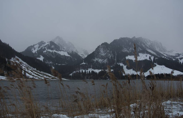 Dark grey mood over winter mountain lake - Photo, Image
