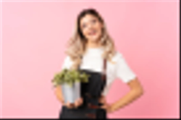 Menina adolescente sobre isolado fundo rosa tendo um vaso de flores
 - Foto, Imagem