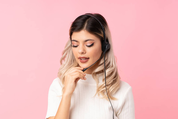 Teenager girl over isolated pink background working with headset - Fotoğraf, Görsel