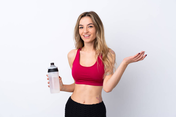 Jonge sport vrouw over geïsoleerde witte achtergrond met sport water fles - Foto, afbeelding