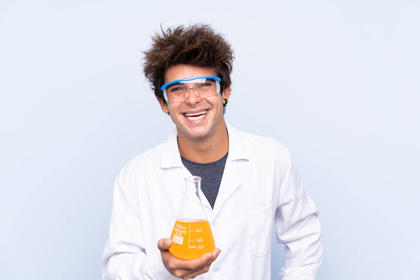Giovane uomo scientifico su isolato sfondo blu ridere
 - Foto, immagini