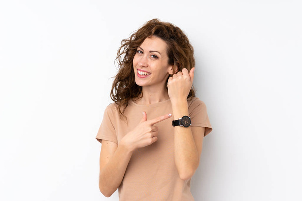 İzole edilmiş arka planda genç güzel bir kadın kol saatini gösteriyor. - Fotoğraf, Görsel