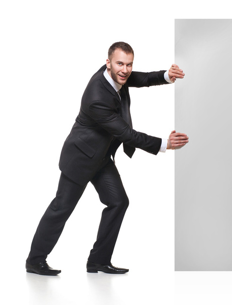 Portrait of business man pushing blank signboard - Фото, зображення
