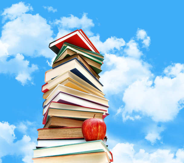 Pilha de livros e maçã contra o céu azul
 - Foto, Imagem
