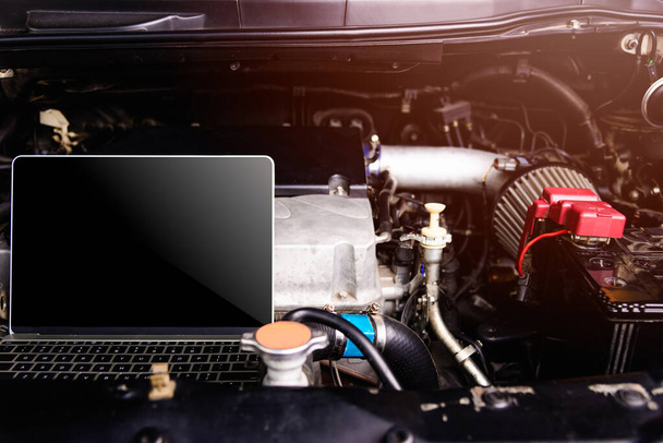 Laptop komputer na mechanika samochodowego silnika do serwisu w warsztacie - Zdjęcie, obraz