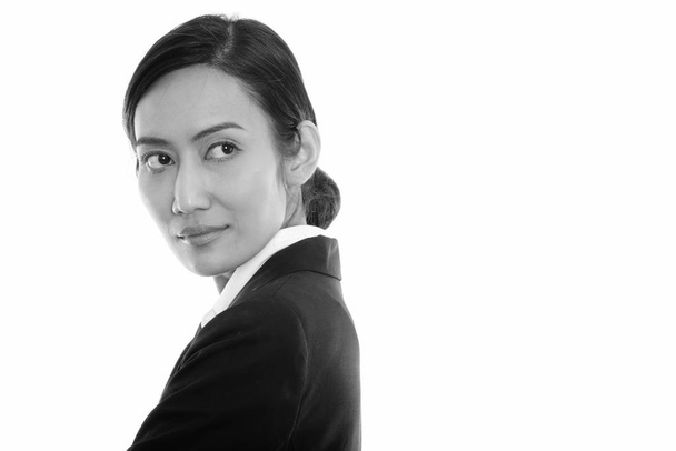 Studio ujęcie młodej azjatyckiej bizneswoman myślenia podczas oglądania się za siebie - Zdjęcie, obraz