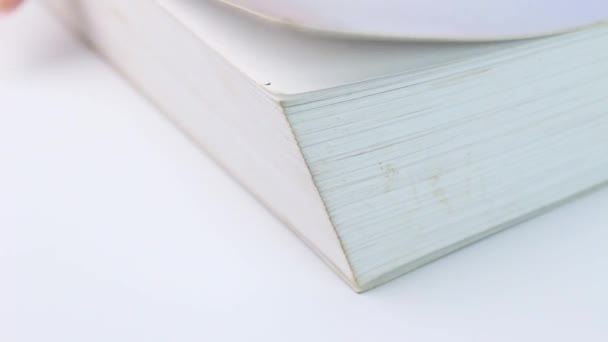 Közelkép Lapozás oldalak egy könyvet a fehér asztal. - Felvétel, videó